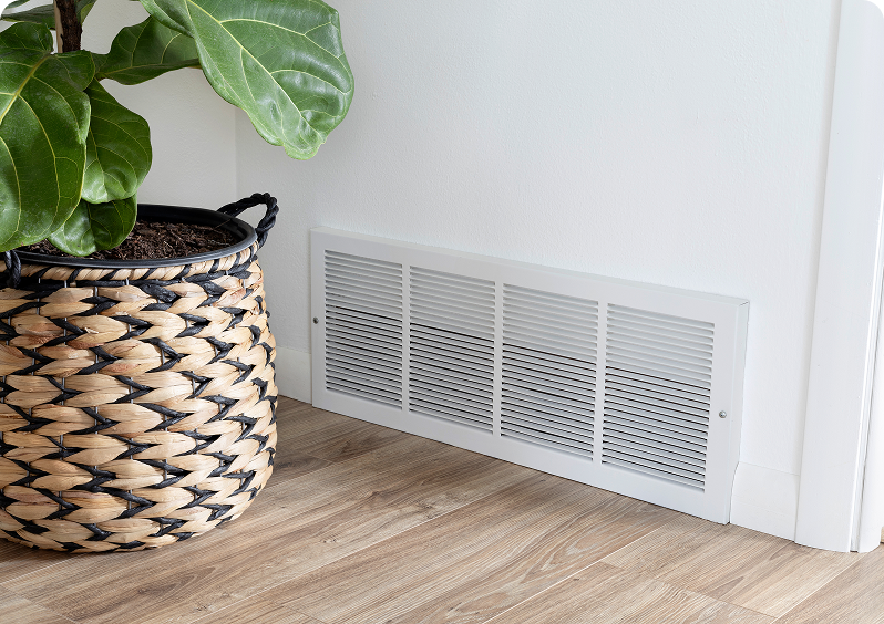 Woven basket plant beside wall vent